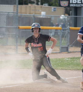 Junior Mo Overbey taking a big slide onto third base and posting up for the picture.